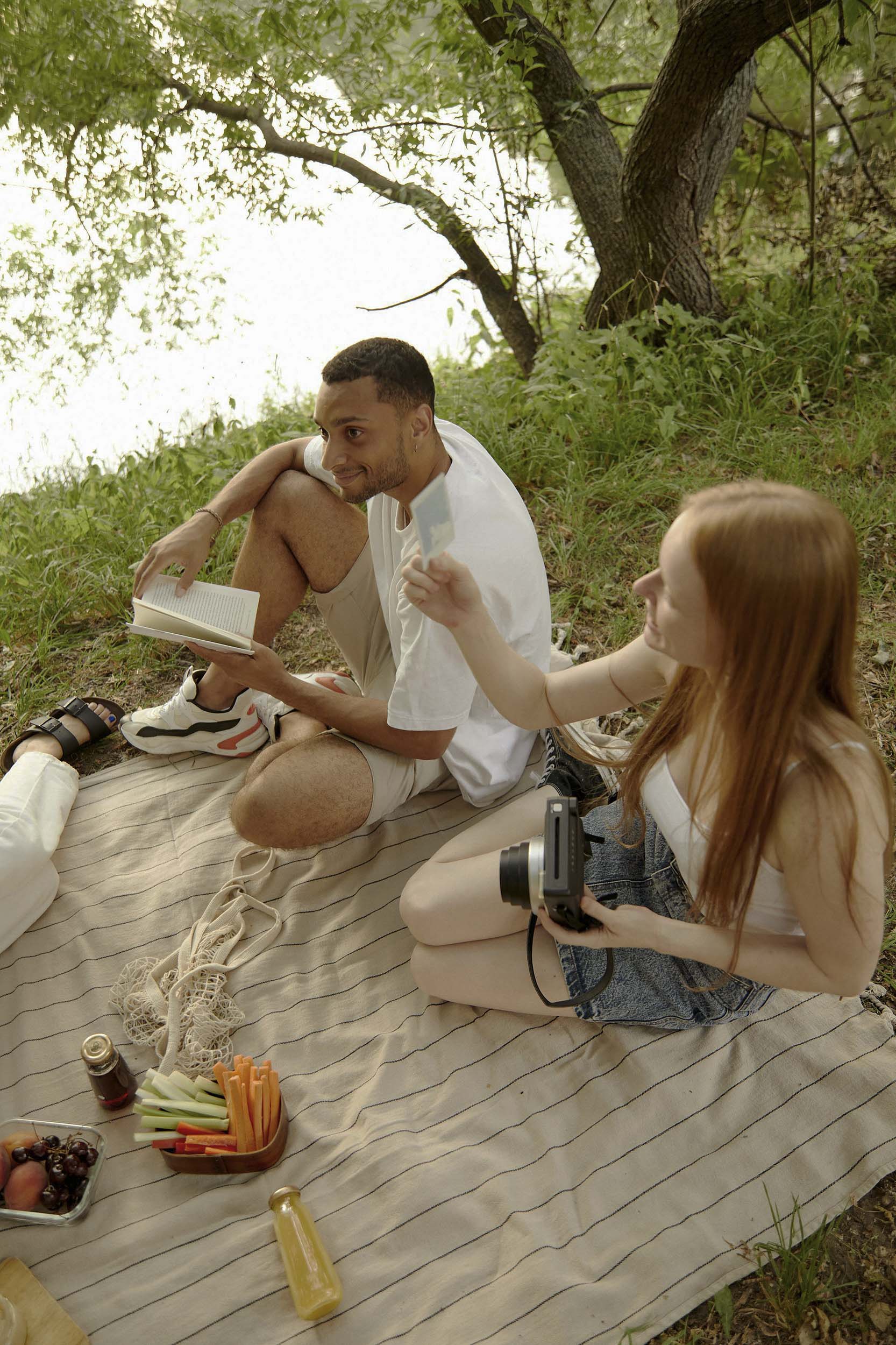 Friends relaxing by a river sharing food and enjoying photography